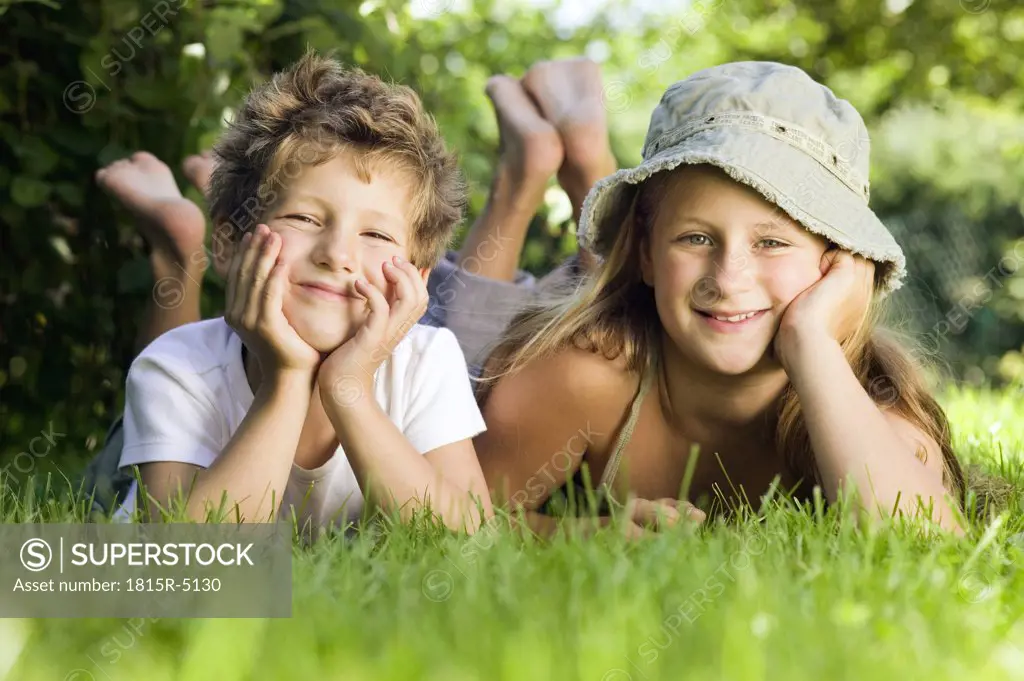 Girl and boy lying in grass
