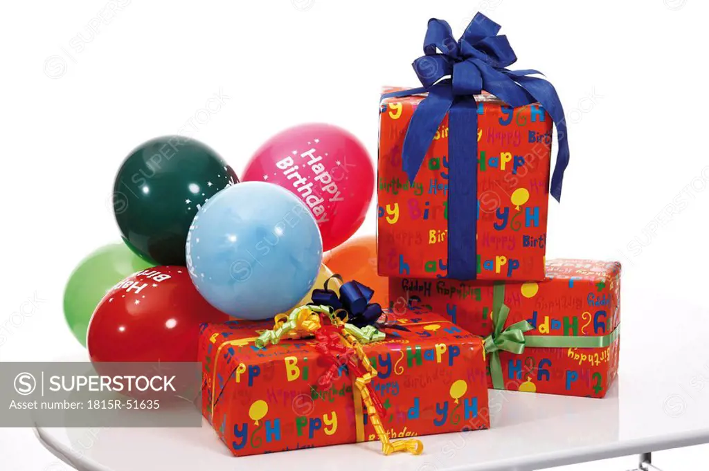Gift parcels and balloons on table