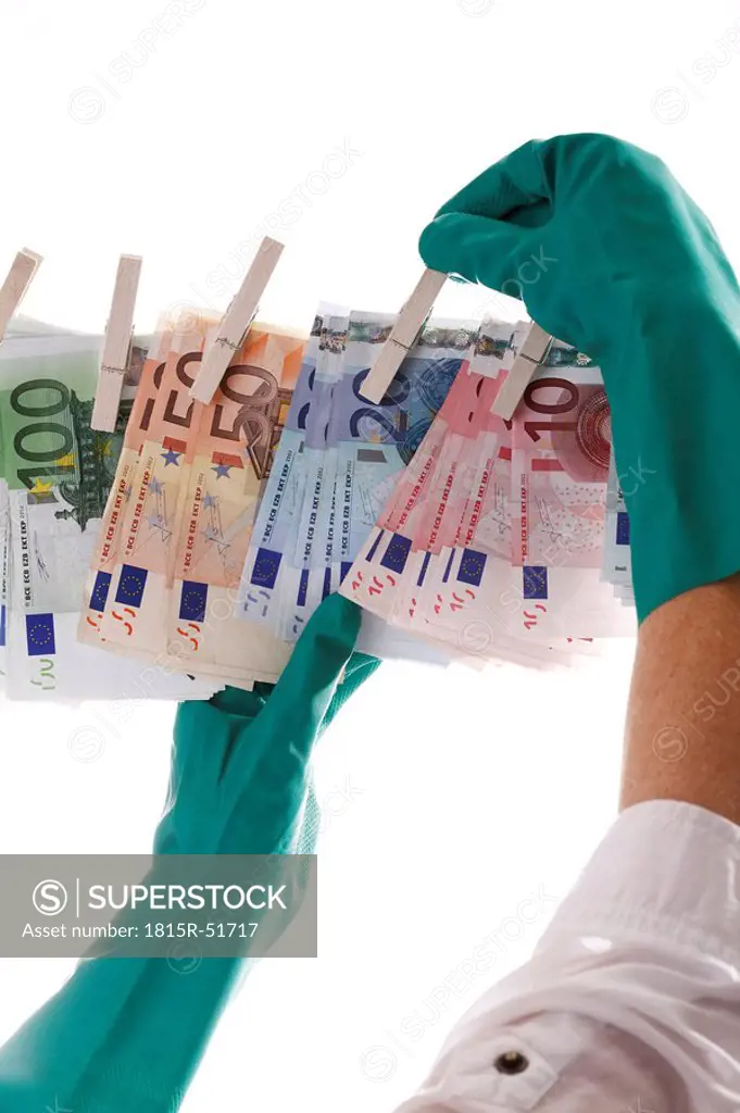Person hanging different Euro notes on clothesline, close_up