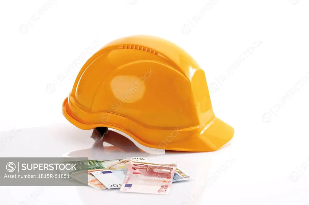 Hardhat and different Euro bank notes in foreground