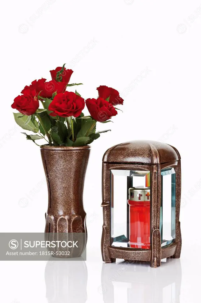 Grave Lantern, grave candle and bunch of red roses in flower vase