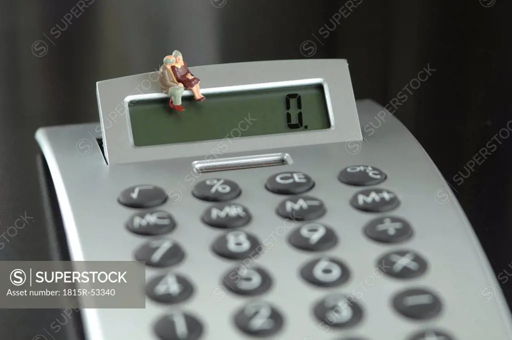 Figurine Senior couple sitting on calculator
