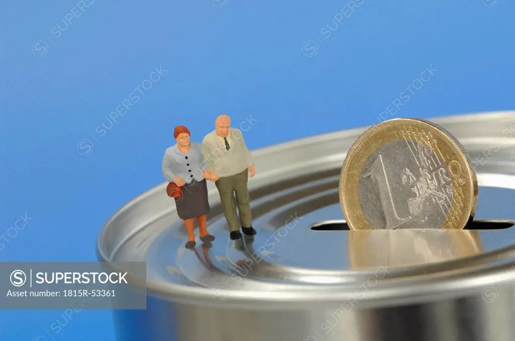 Figurines of senior couple on money box
