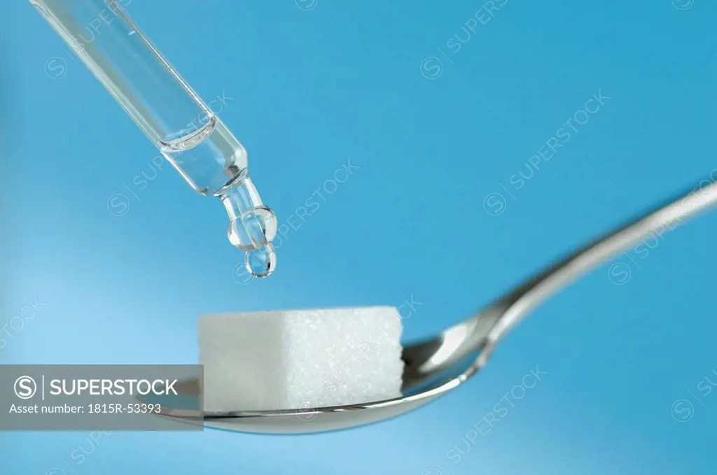 Drop falling from a pipette onto sugar cube