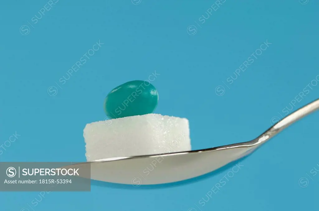 Sugar cube and pill on spoon