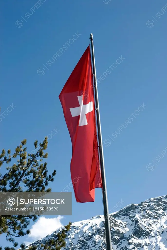 Switzerland, Arosa, Swiss flag on flag pole under blue sky