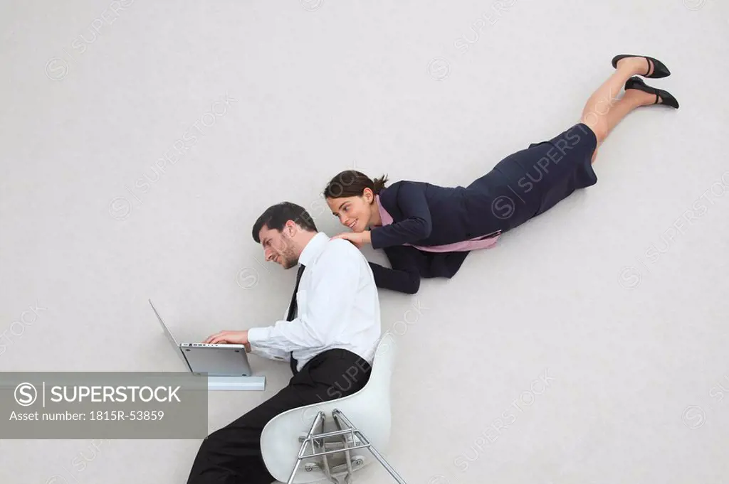 Businessman and businesswoman using laptop, portrait, elevated view