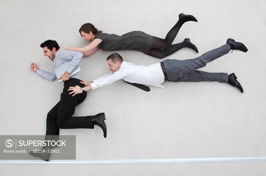 Businessman on the run, two colleagues after him, flying in the air, side view