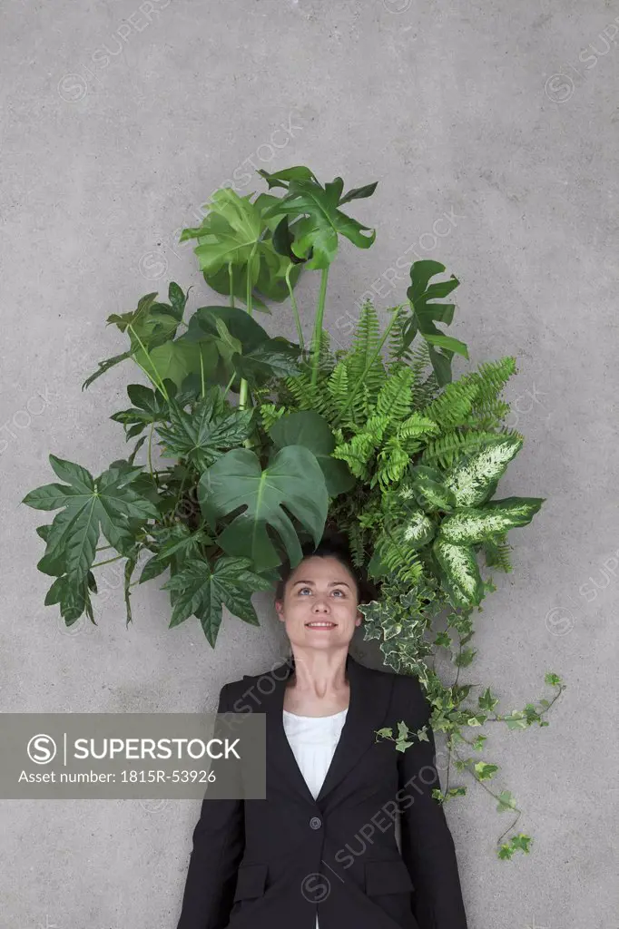 Businesswoman with foliage plants on head, smiling, portrait, elevated view