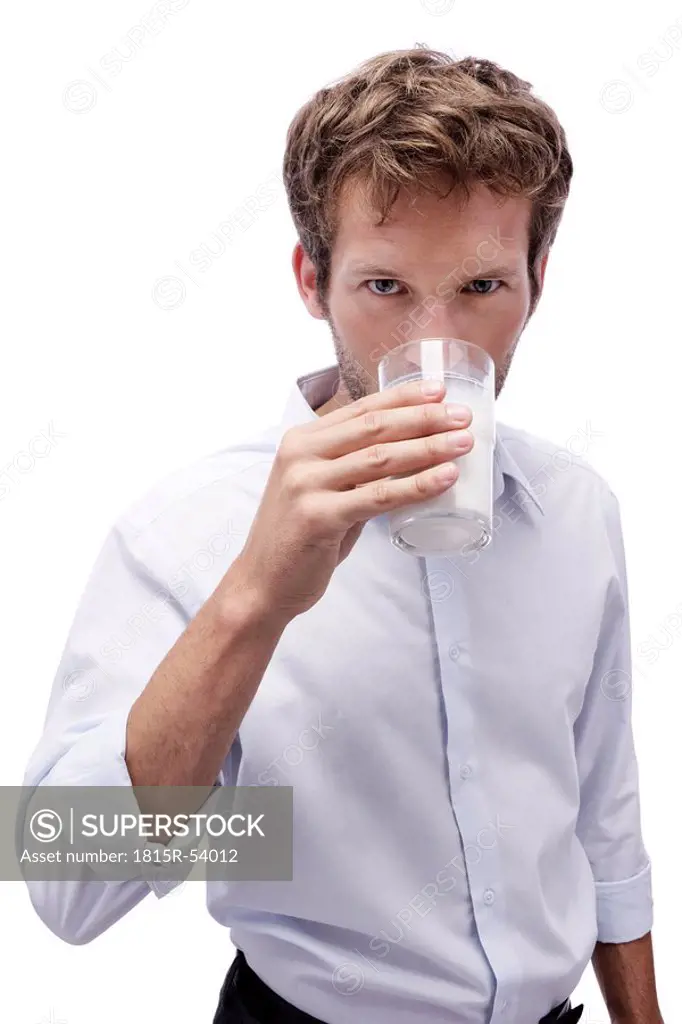 Young man drinking a glass of milk, portrait