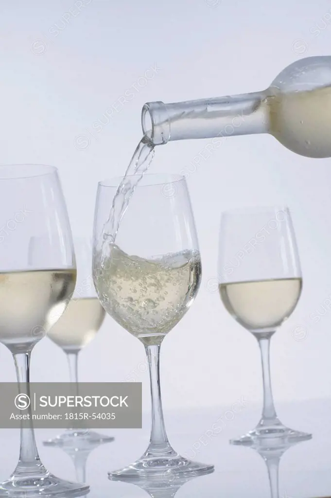 Pouring white wine in wine glasses
