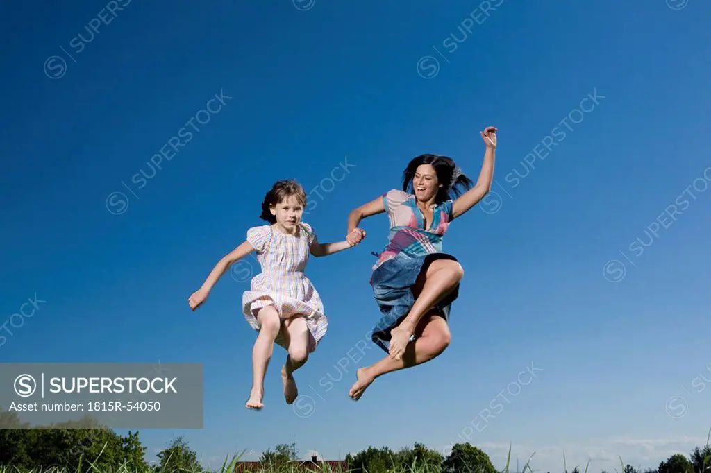 Mother and daughter 6_7 hand in hand, jumping high