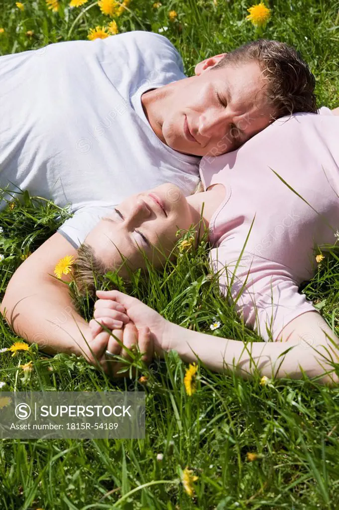 Germany, Bavaria, Munich, Young couple lying in meadow, elevated view