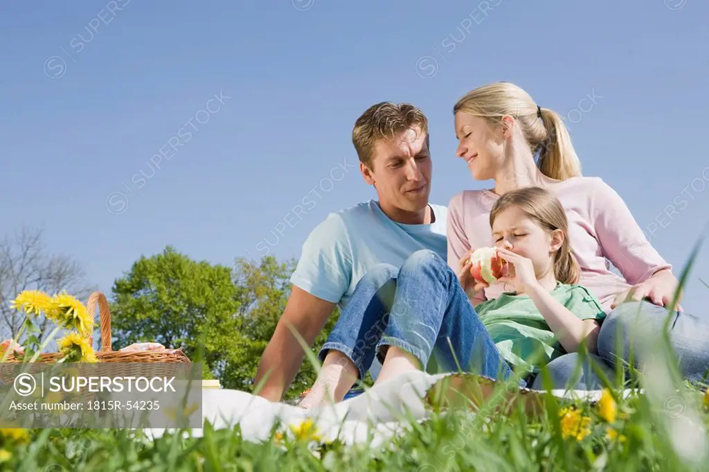 Germany, Bavaria, Munich, Family having picnic, girl 6_7 holding an apple, portrait