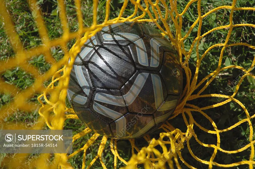Germany, Bavaria, Close_up of a soccer ball in a net