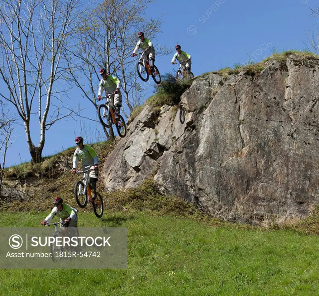 Italy, Lake Como, Group of mountain bikers riding across rock