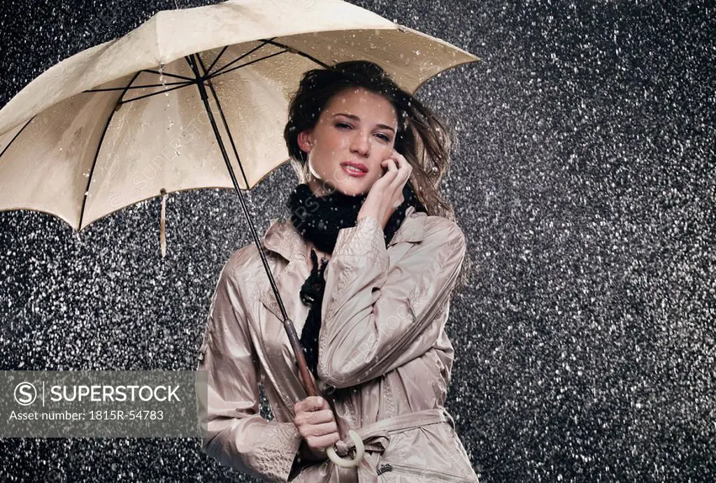 Woman on the phone, holding umbrella.