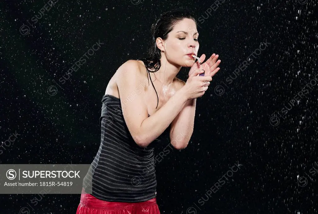 Woman lighting cigarette in rain
