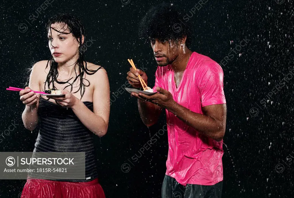 Men and women eating in rain.