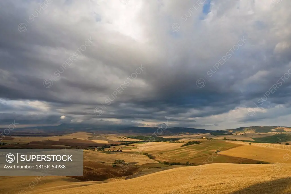 Italy, Tuscany, Harvested corn fields and thunderclouds