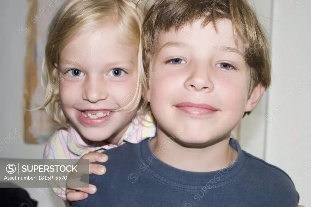 Boy and girl (3-5) smiling, close-up, portrait