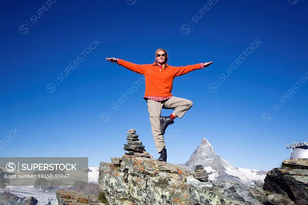 Switzerland, Wallis Alps, Matterhorn, Woman balancing on rock