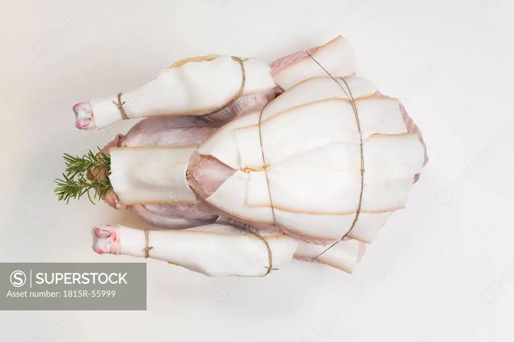 Raw Turkey with bacon slices, elevated view