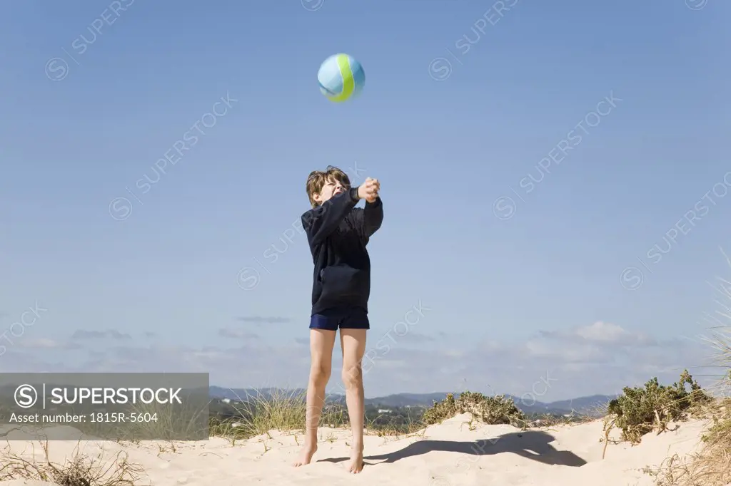 Portugal, Algarve, boy (8-11) playing with ball at beach