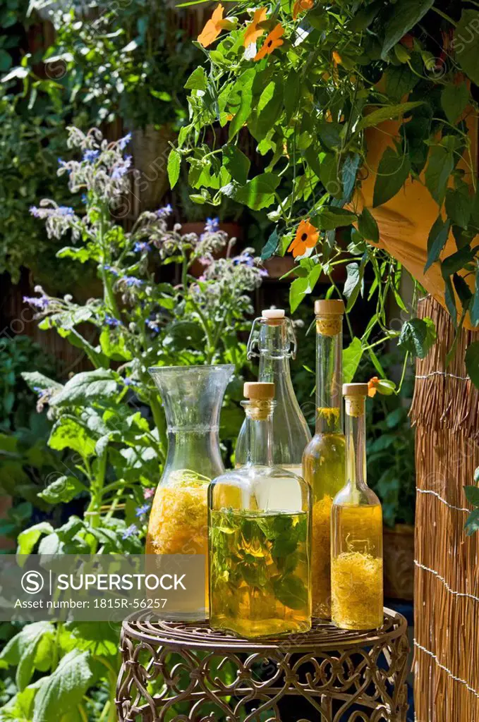 Austria, Salzburger Land, Different bottles with vinegar and oil plced on side table in garden