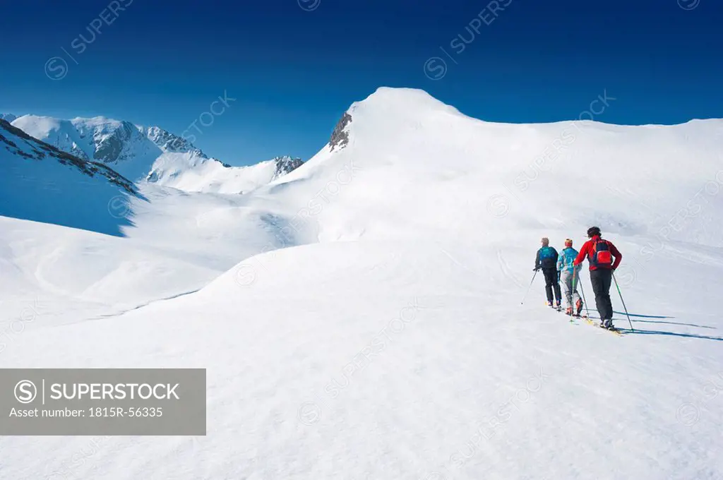 Austria, Salzburger Land, Altenmarkt, Zauchensee, Three persons cross country skiing in mountains