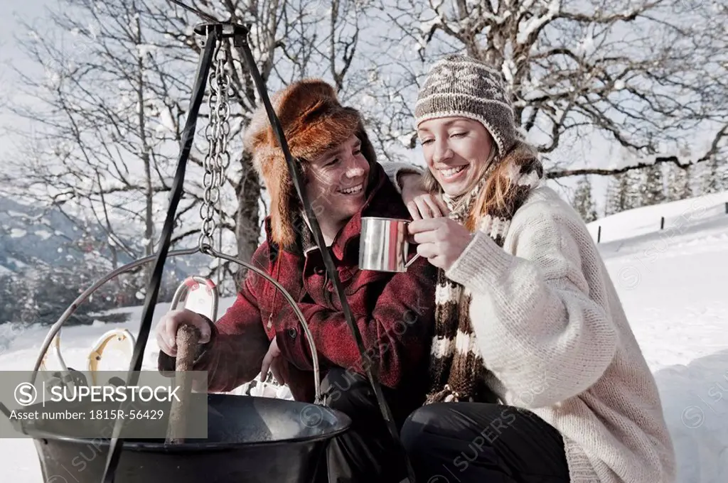 Austria, Salzburger Land, Couple cooking on campfire