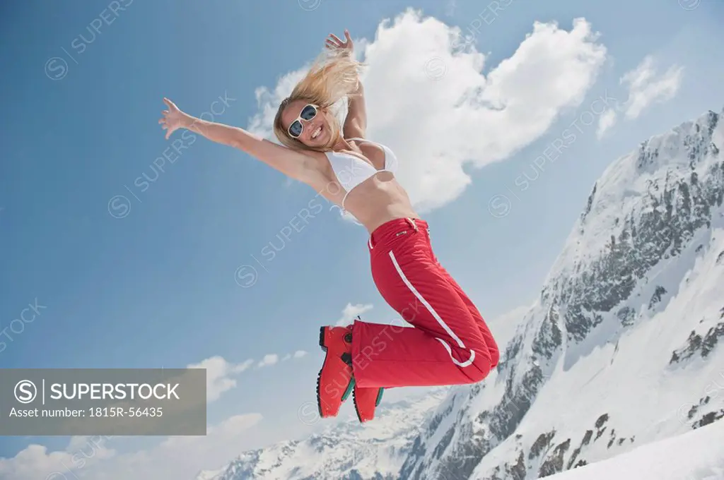 Austria, Salzburger Land, Young woman jumping in air