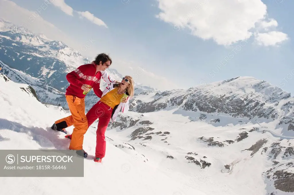 Austria, Salzburger Land, Couple having fun, holding glasses, laughing, portrait