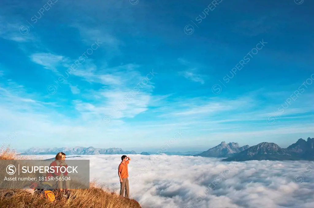 Austria, Steiermark, Reiteralm, Hikers admiring view over clouds