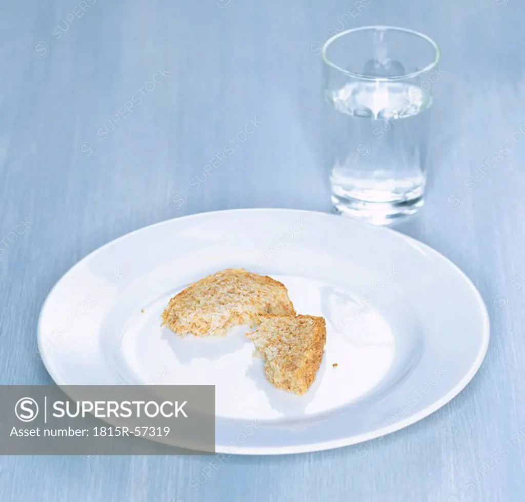 Bitten whole meal toast on plate, in background glass of water