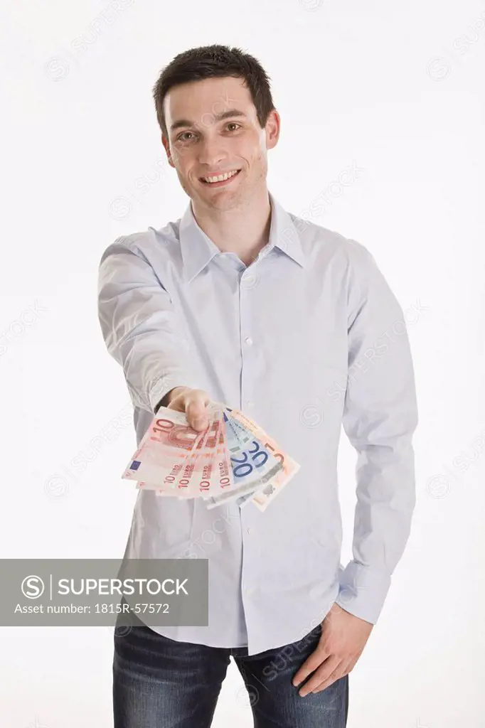 Businessman holding Euro notes, smiling, portrait