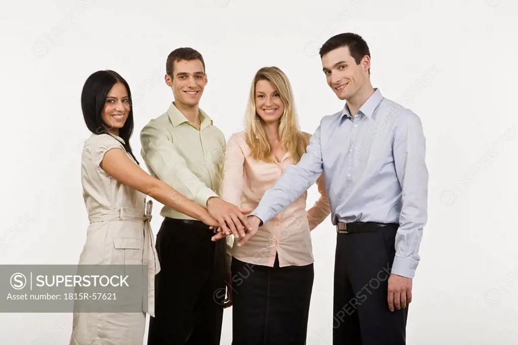 Businesspeople in a huddle, smiling, portrait