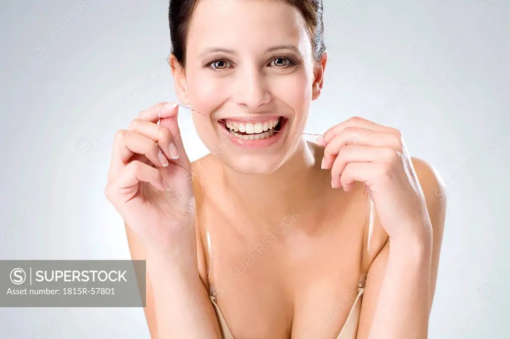 Young woman flossing her teeth, close up