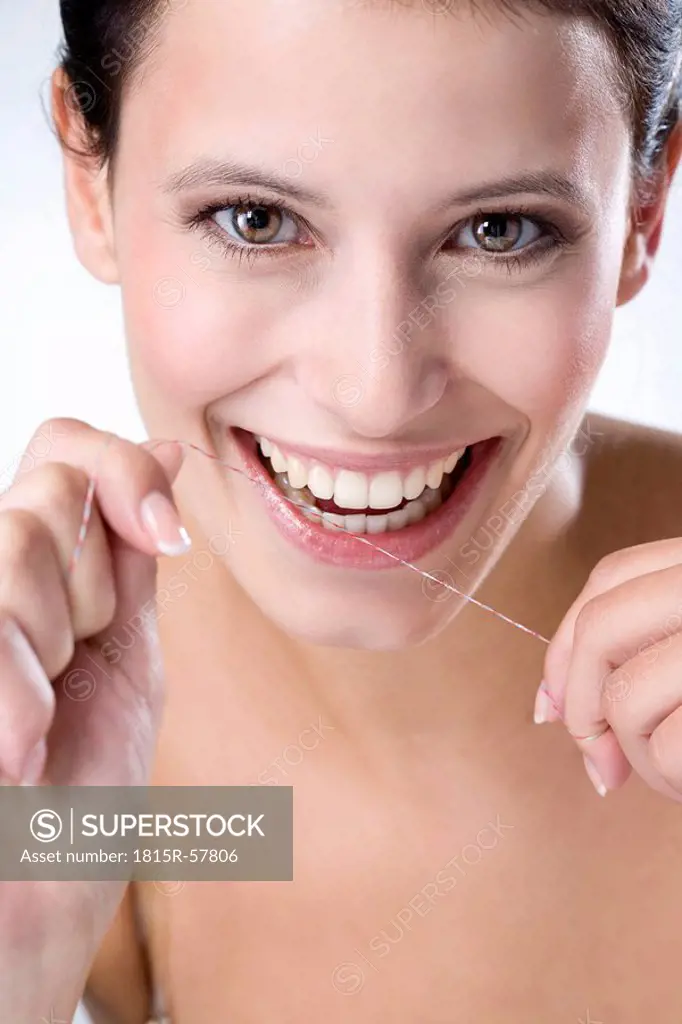Young woman flossing her teeth, close up