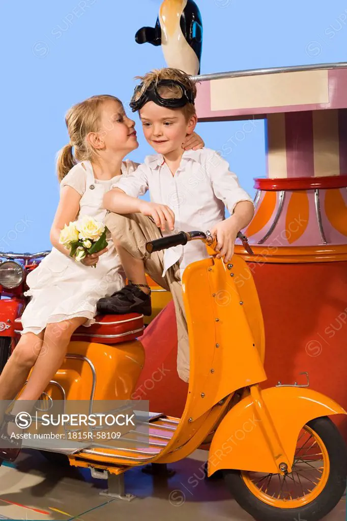 Germany, Landshut, girl kissing boy 4_5, sitting in carousel