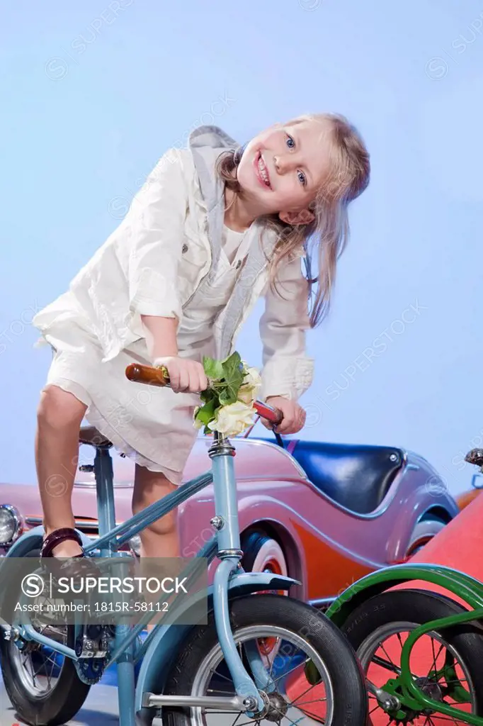 Germany, Landshut , little girl 4_5 riding carousel bike, smiling