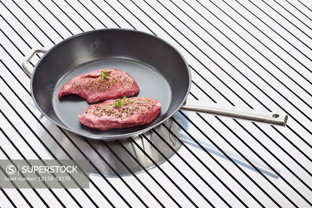 Raw steak in frying pan, elevated view