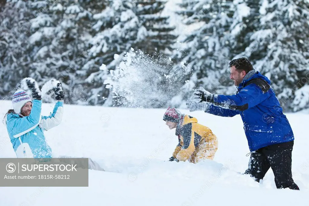 Germany, Bavaria, Family having snowball fight