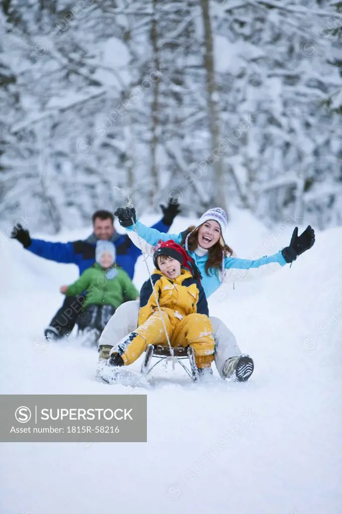 Germany, Bavaria, Family sledding, having fun