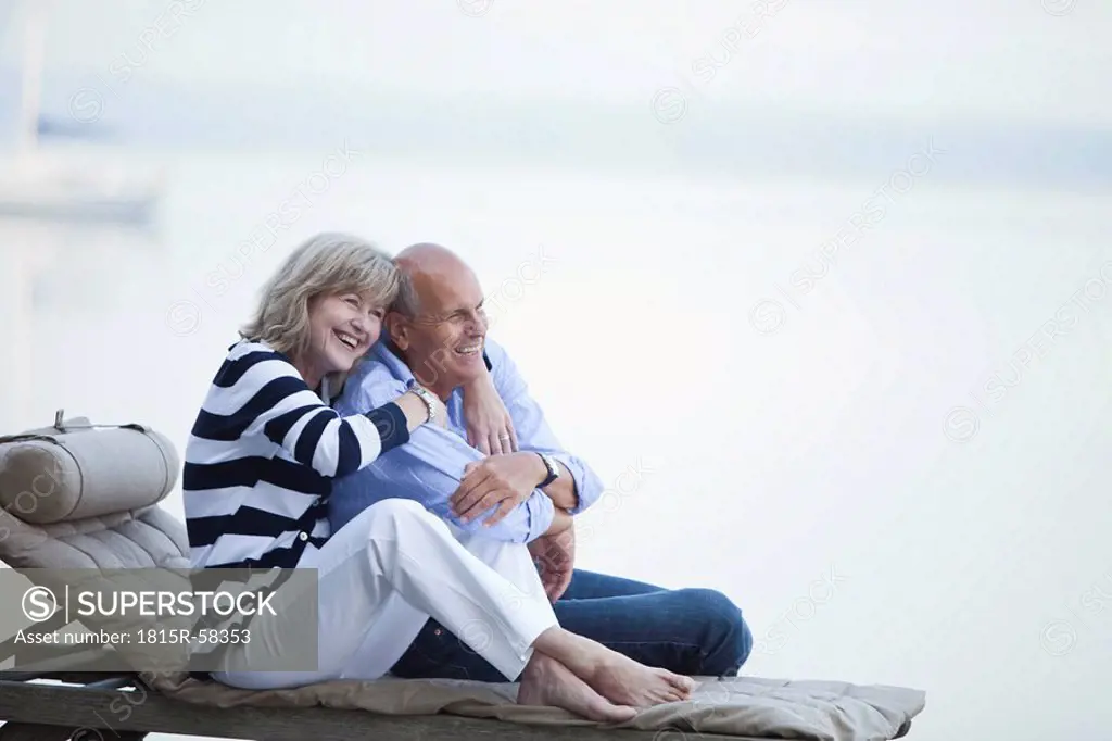 Germany, Bavaria, Starnberger See, Senior couple sitting on sunlounger on jetty