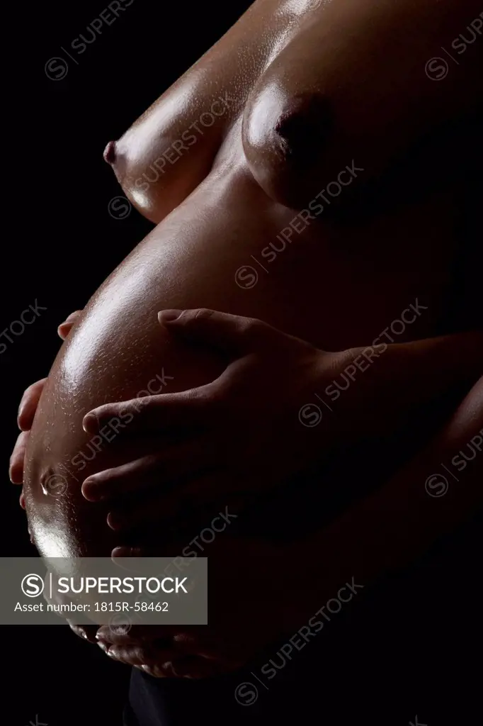 Woman and man´s hands holding pregnant belly