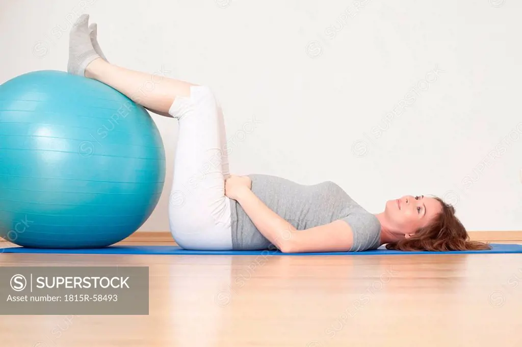 Pregnant woman lying on gymnastic mat