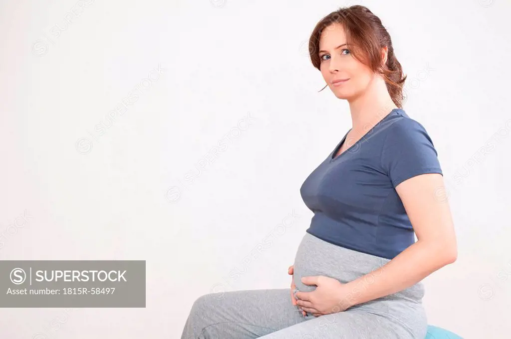 Portrait of a pregnant woman sitting on exercise ball, portrait