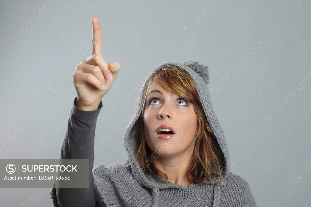 Woman pointing upwards, portrait