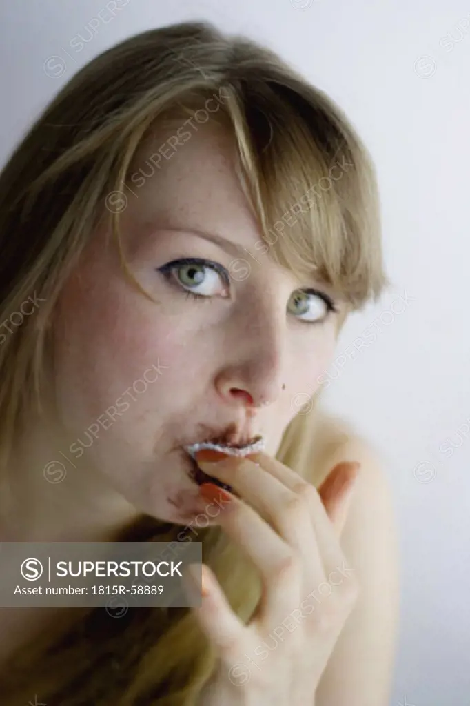 Young woman eating chocolate marshmallow
